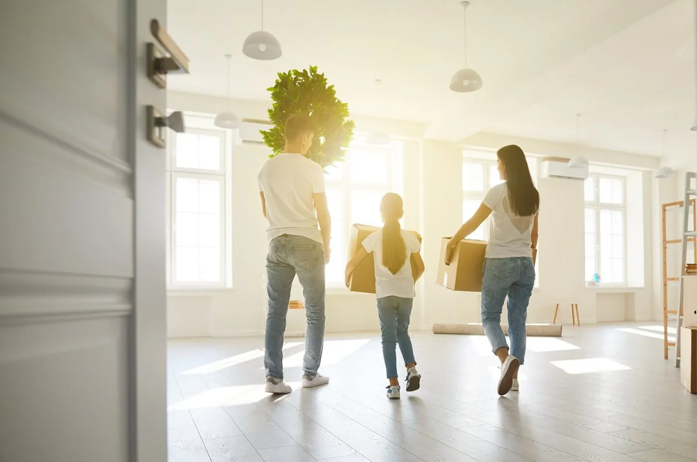 A family carrying boxes into their new home