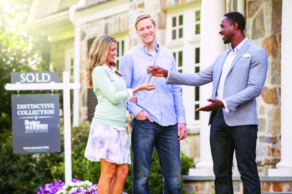 Agent handing keys to new homeowners