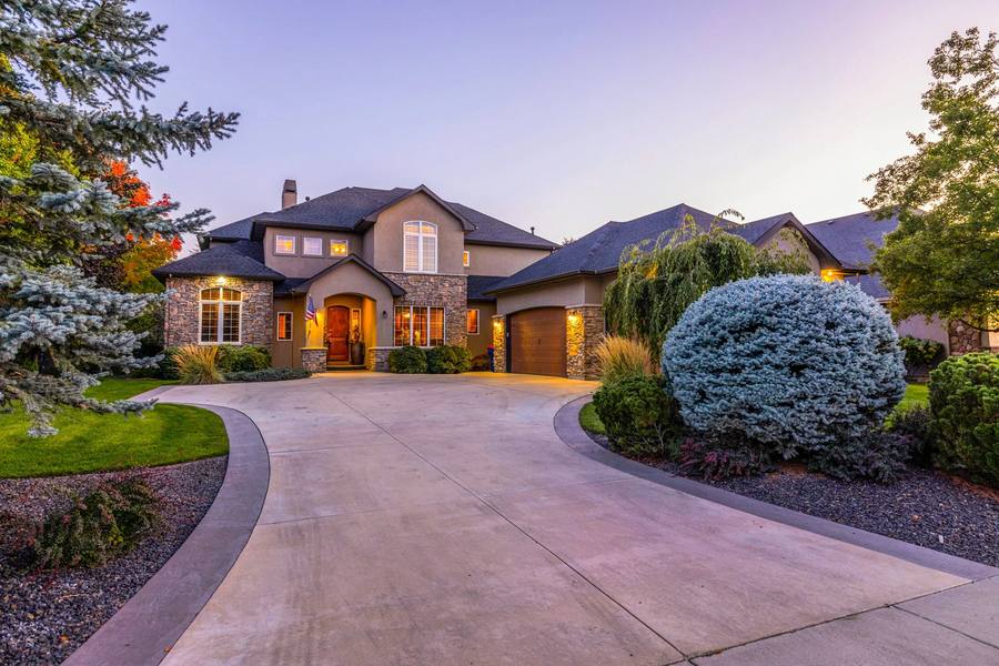 Stone and stucco luxury estate with a curved drive at dusk