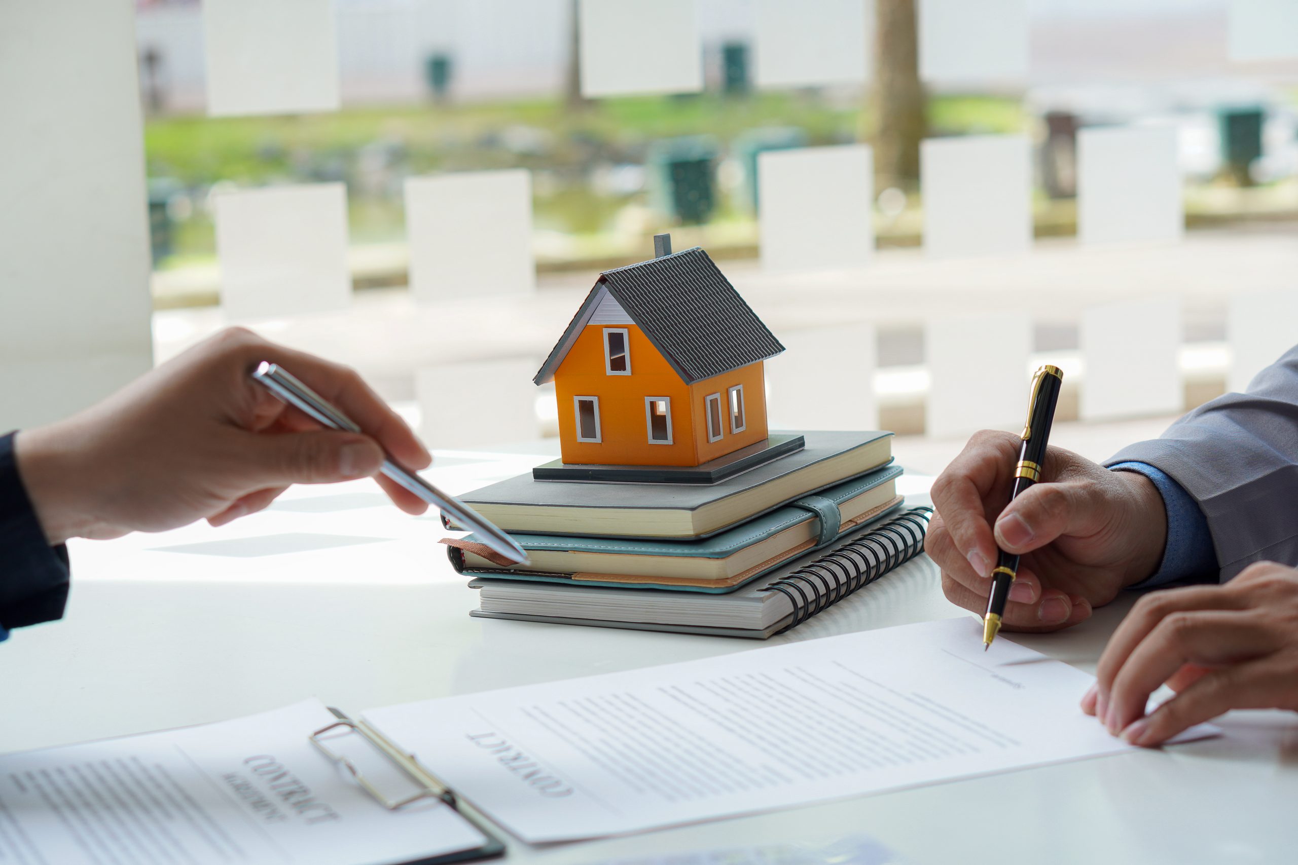 The real estate agent or bank officer explains the interest on the loan to the customer with a home loan agreement to his client after signing the contract. real estate concept