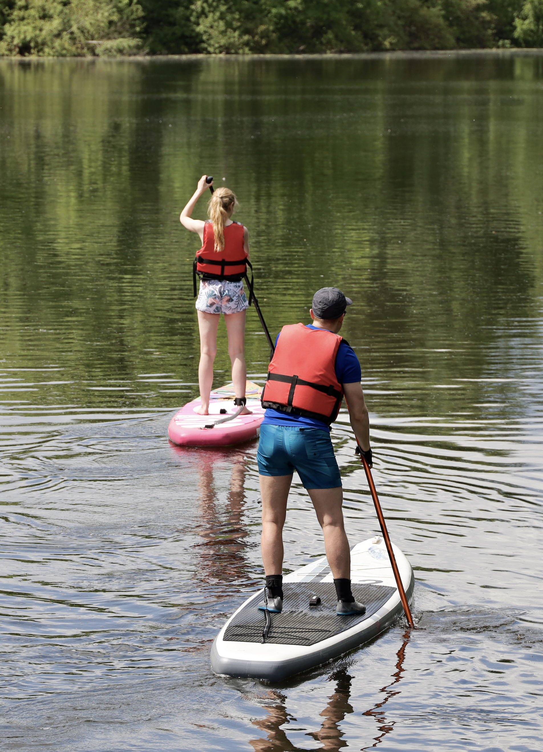 2 People Paddleboarding on River