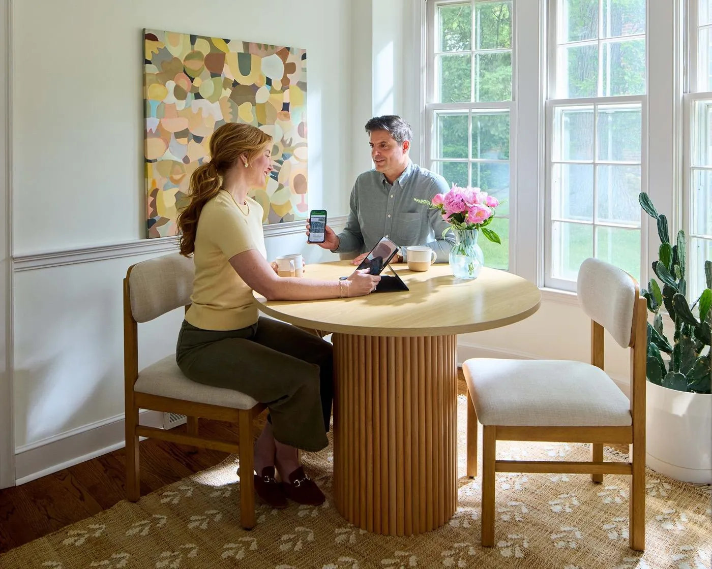 An agent and a client reviewing a plan at the kitchen table