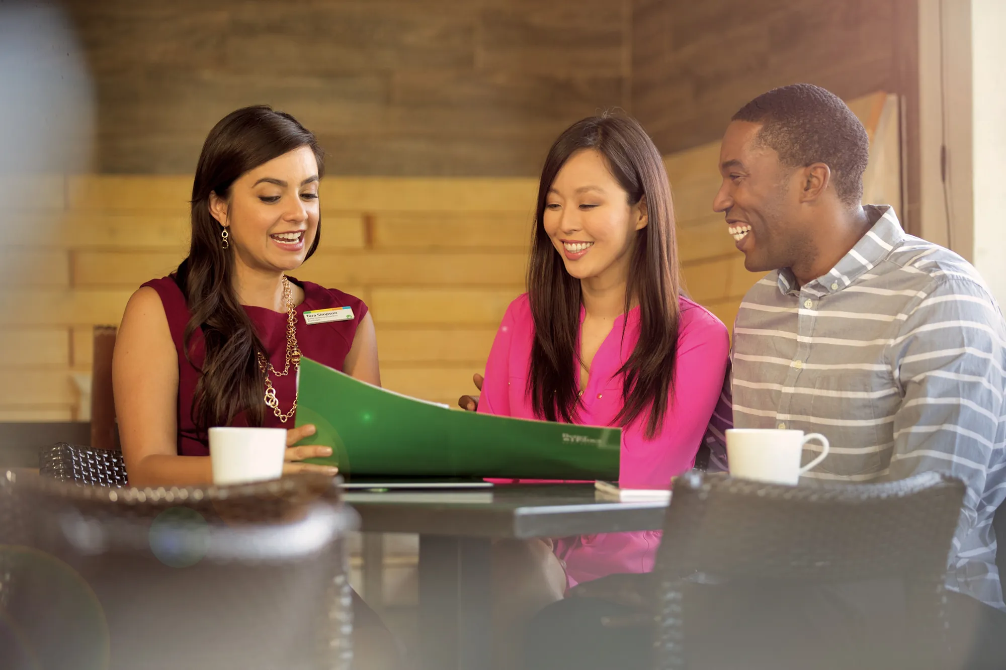 A BHGRE 43° North agent reviewing a market report with homeowners