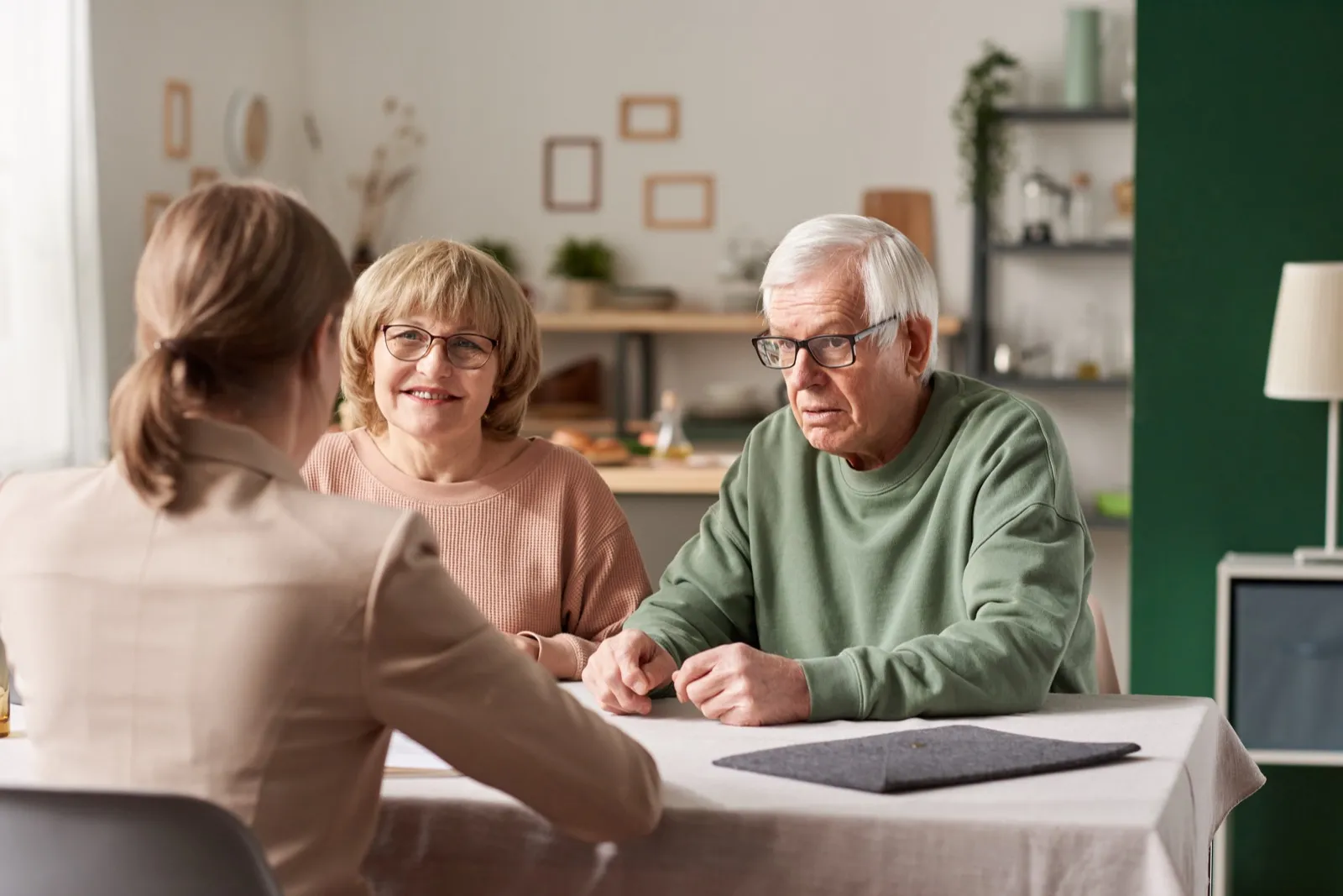 Agent sitting with an older couple at their dining table